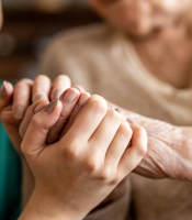 Carer holding hand of elderly dependant
