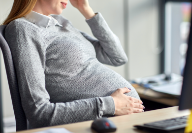 Pregnant employee looking stressed