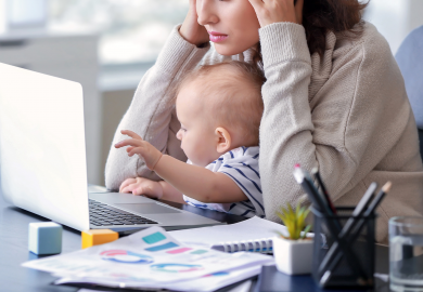 Stressed woman trying to work at laptop with baby on lap