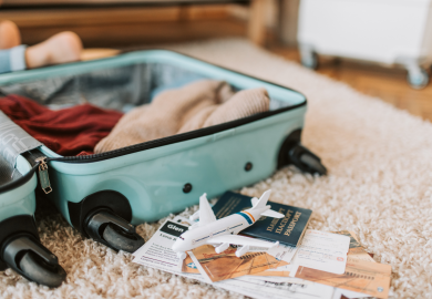 Open suitcase with passport and documents